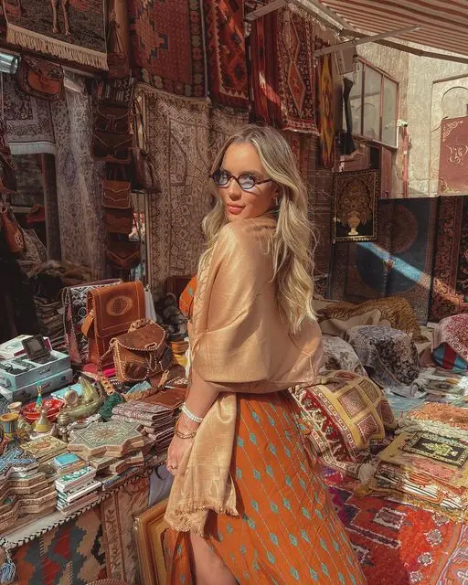 Solo female traveler enjoying the vibrant streets of Marrakech, Morocco with traditional architecture in the background